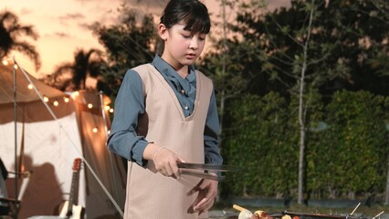 Family gather celebrate holiday, Adorable child grill food for family member. Outdoor camping...