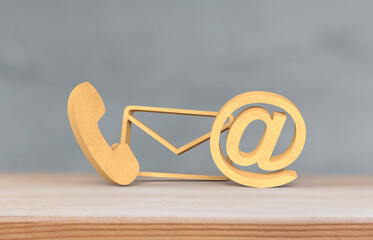 Modern Communication Symbols: Phone, Email, and At Icon on Wooden Surface