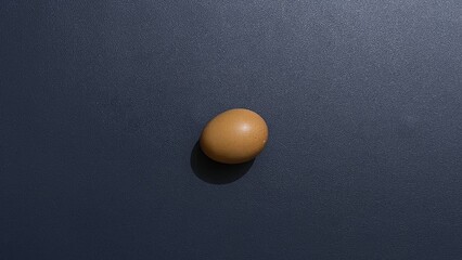 A Single Brown Egg on a Dark Blue Background A Minimalist Still Life Photography