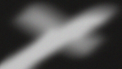 A blurred monochromatic image featuring a glowing cross shape against a dark background with a grainy texture.