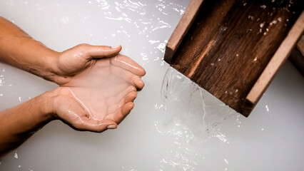 Close-up of a woman's hands touching powdery white water in a Japanese bath. A serene spa moment, perfect for relaxation, wellness, and peaceful retreat concepts.