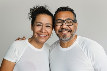 Fototapeta premium Portrait of a cheerful latino couple in their 30s sporting a breathable mesh jersey over plain white digital canvas