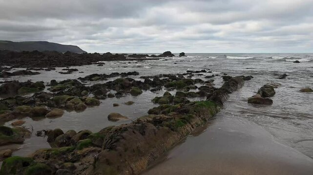 Rocks exposed by the low tide on Cornwall beach in winter