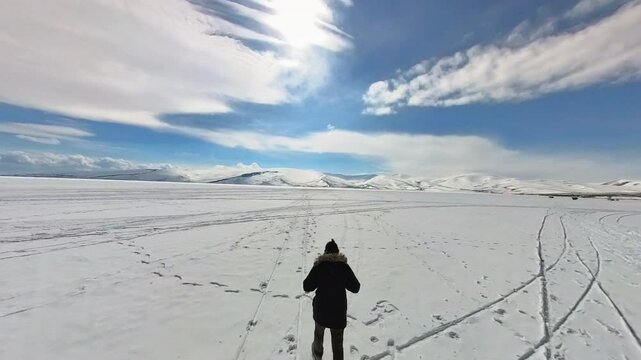 Young traveller man is walking on the frozen lake, Cildir Lake , Turkey