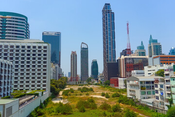 Obraz premium Vacant lot is an area free of buildings, overgrown with grass, surrounded by modern buildings in a city