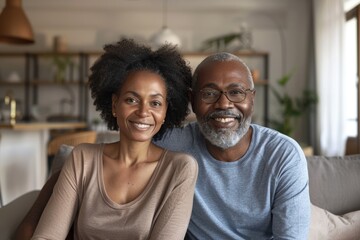 Portrait of a tender multicultural couple in their 60s showing off a lightweight base layer in front of crisp minimalistic living room