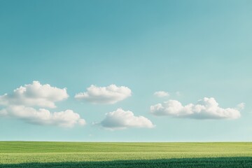 Fototapeta premium A serene landscape image featuring a lush green grass field under a bright blue sky with fluffy white clouds