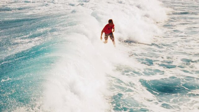 Wave surfing aerial. Man surfs the wave in the Maldives