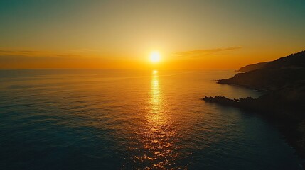 Vibrant sunset over calm ocean and rocky coast.