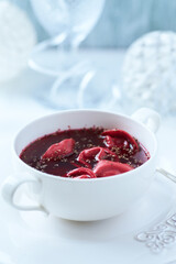 Traditional Christmas Borscht (Barszcz) with mushroom dumplings on bright background.