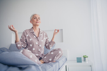 Elderly woman enjoying a peaceful morning meditation at home in her cozy pajamas