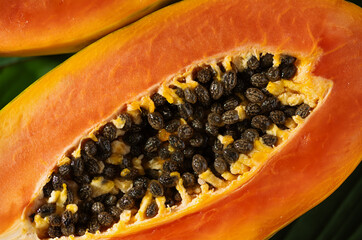 Juicy papaya slices top view showcase this vitamin rich fruit. Tropical papaya fruit cut in half, with seeds and bright orange flesh displayed.
