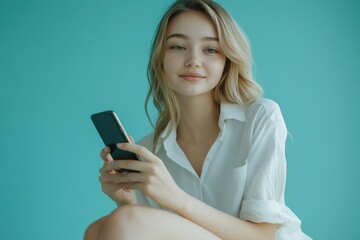 Fototapeta premium A woman holds her cell phone with a look of concern on her face