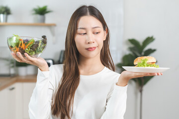 Diet, Dieting asian young woman, girl confused choose, choice eating food, hand holding bowl of...