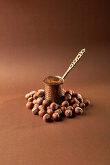 dark coffee  surrounded by roasted hazelnuts 