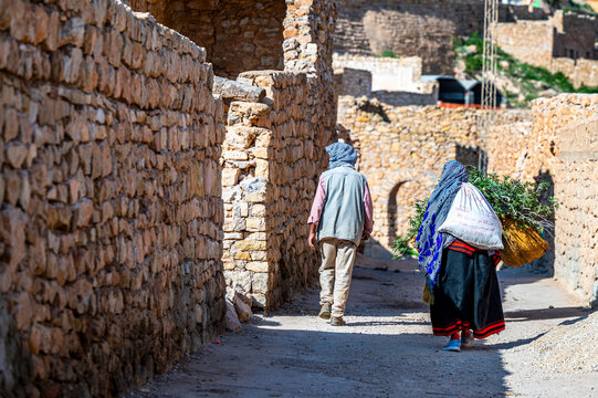 Man and woman in traditional Berber clothes at the background of the buildings of the village of Toujane in southern Tunisia.