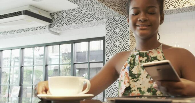 Young girls using e-payment with mobile to buy hot drink in coffeeshop