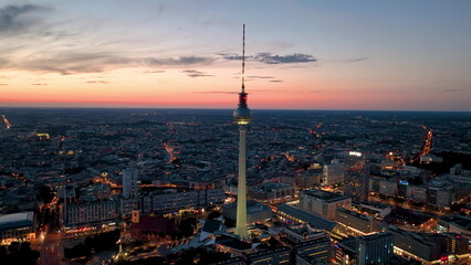 Aerial video shows a vibrant cityscape with a majestic tower famous places architectural landmarks TV Tower, Alexanderplatz at night. Berlin, Germany