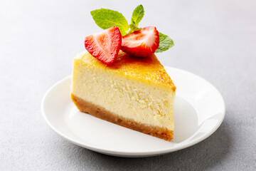 Cheesecake dessert with fresh strawberries. Grey background. Close up.