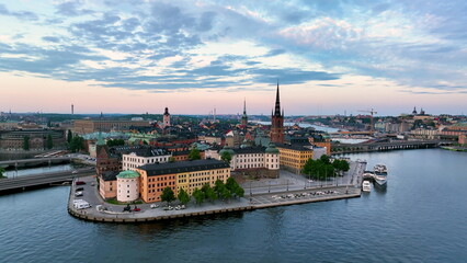 Aerial footage highlights a vibrant cityscape by serene water Riddarholmen Church, Stockholm City Hall. Sweden