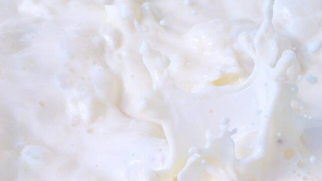 Fresh organic strawberries falling into milk, creating creamy splashes in slow motion 300fps