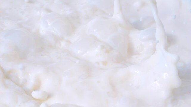 Fresh organic strawberries falling into milk, creating creamy splashes in slow motion 300fps