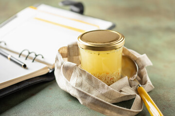 Chicken soup with  pasta in a glass jar on the table. Healthy office snack