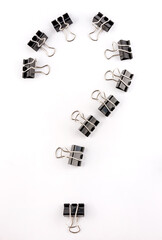 Black binder clips on a white background. Question mark of binder clips.