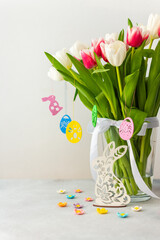 Spring bouquet of pink and white tulips and bunny looking for Easter eggs