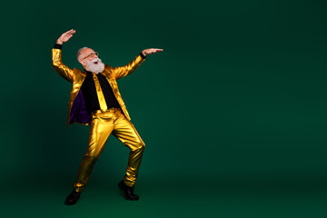 Charismatic elderly gentleman in golden suit enjoying lively dance moves and joyful holiday atmosphere against vibrant green background