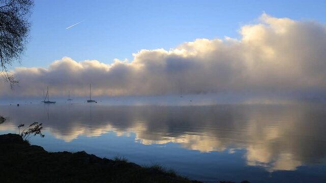 Morgenstimmung am Simssee in Bayern mit Fischerbooten und aufsteigendem Nebel