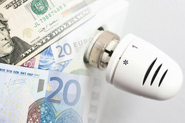 Thermostat set to zero with snowflake icon and money. Rising home heating costs in winter. Cold...