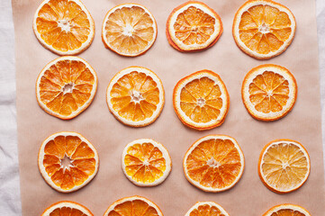 Delicious dried orange on baking sheet and white linen Christmas decoration diy recipe copy space flat lay top view holiday inspiration