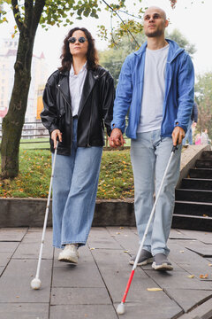 blind couple with visual impairments using white canes to walk confidently