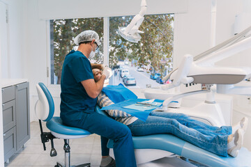 Dentist performing dental procedure in modern clinic office