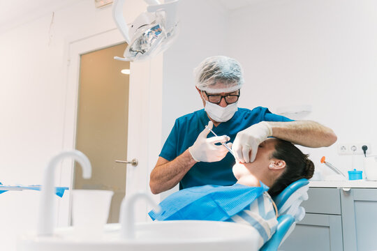 Dentist performing procedure in modern dental clinic office