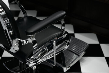 Classic barber chair in modern barbershop with black and white floor design