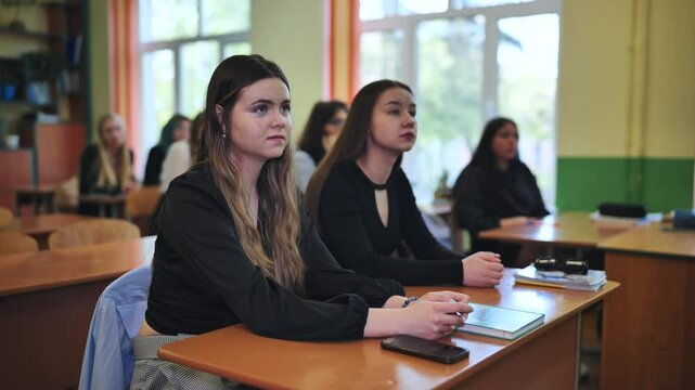 High school students actively engaged in a classroom lesson, listening attentively to their teacher