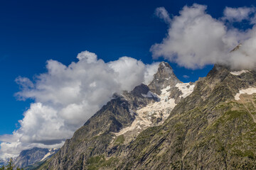 Val Ferret mountain landscape in the Alps. Tour du Mont Blanc beautiful scenic view from the hiking path on the way from Itlay to Switzerland. Alpine meadow and high snow peaks of the Alps on the sun