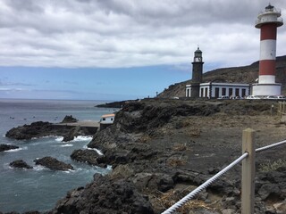 Coastal lighthouse at siestapixel under cloudy sky