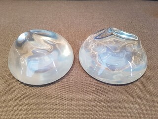Silicone breast augmentation surgery, two-piece smooth silicone breast implants, brown background,...