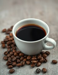 Fototapeta premium Freshly brewed coffee in a white cup surrounded by roasted coffee beans on wooden surface