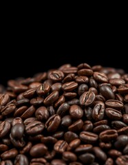 Freshly roasted coffee beans piled high against a dark background for an enticing and aromatic display