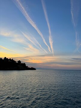 Sunrise sky clouds over calm sea and coast 