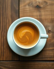 Warm cup of coffee sitting on a wooden table with beautiful latte art swirling in the frothy surface