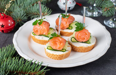 Festive canape with salted salmon, cucumber, soft cheese and parsley