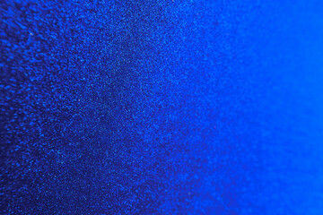Bright Blue Glitter Texture Background. Abstract close-up of a bright blue glittery texture,...