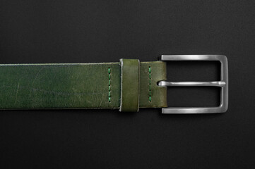 Green leather belt close up on a black background