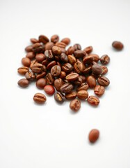 Obraz premium Coffee beans spread out on a white surface showcasing their rich brown color and distinct shapes in bright lighting