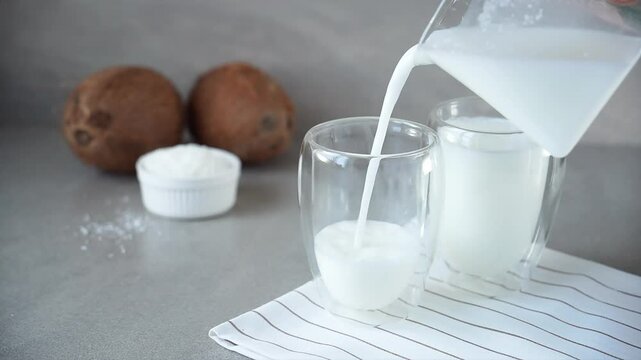 fresh vegetable coconut milk is poured into a transparent glass
